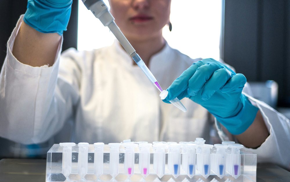 Scientist pipetting samples into tubes for sequencing